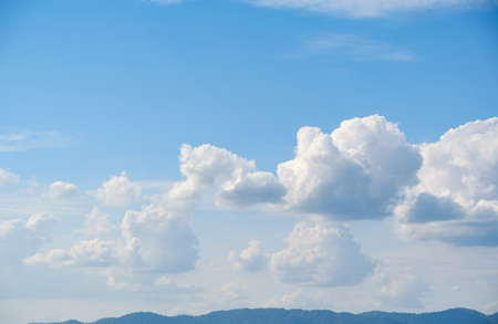 The white clouds have a strange shape and country side.Cloudy and blue sky.Cloud and mountains