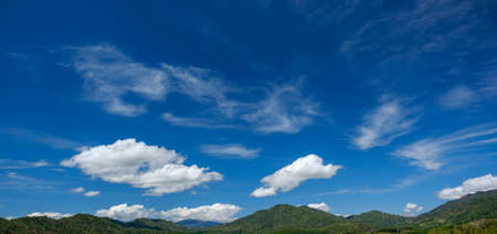 The white clouds have a strange shape and moutain.The sky and the open space have mountains below.Clouds floating above the mountains.の写真素材