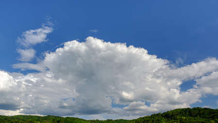 The white clouds have a strange shape and moutain.The sky and the open space have mountains below.Clouds floating above the mountains.の写真素材