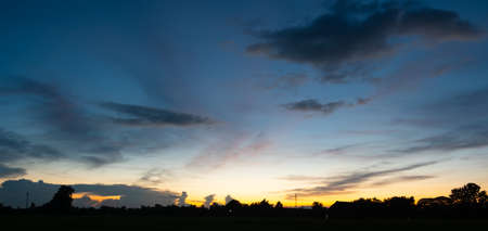 Colorful sunset and sunrise with clouds.Blue and orange color of nature.Many white clouds in the blue sky.The weather is clear today.sunset in the clouds.The sky is twilight.の写真素材