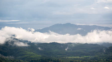 The white clouds have a strange shape and moutain.The sky and the open space have mountains below.Clouds floating above the mountains.の写真素材