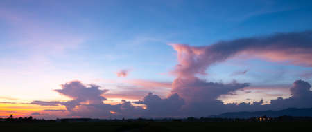 Colorful sunset and sunrise with clouds.Blue and orange color of nature.Many white clouds in the blue sky.The weather is clear today.sunset in the clouds.The sky is twilight.の写真素材