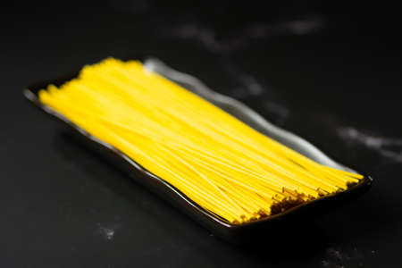 Selective focus yellow noodles in dish.food and copy space.raw pasta.Rice vermicelli and space.の写真素材