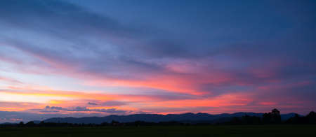 Colorful sunset and sunrise with clouds.Blue and orange color of nature.Many white clouds in the blue sky.The weather is clear today.sunset in the clouds.The sky is twilight.の写真素材