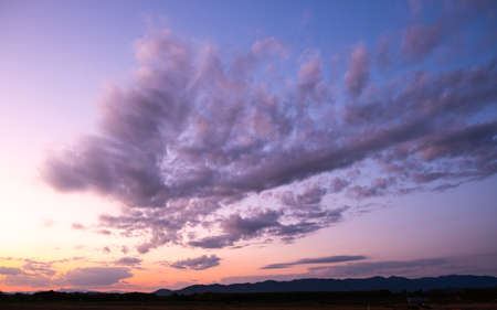 Colorful sunset and sunrise with clouds. Blue and orange color of nature. Many white clouds in the blue sky. The weather is clear today. sunset in the clouds. The sky is twilightの写真素材