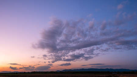 Colorful sunset and sunrise with clouds. Blue and orange color of nature. Many white clouds in the blue sky. The weather is clear today. sunset in the clouds. The sky is twilightの写真素材