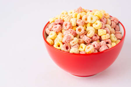 Cereal flakes in red bowl with copy space,Breakfast concept.Food with delicious fruity taste and fruity colours.It's made with maize,wheat,and barley.topview and copy space.white backgroundの写真素材