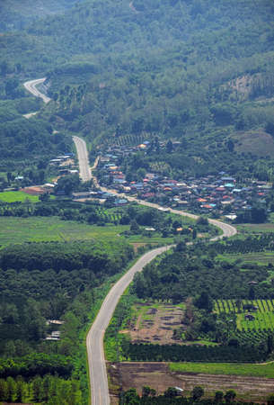 The village in the middle of the mountains.The road cuts through the villageの写真素材