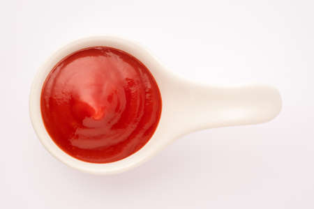 Tomato ketchup in ceramic bowl on white background.の写真素材