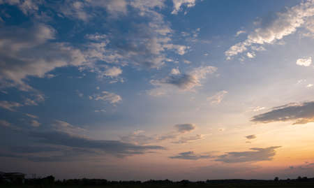 Colorful sunset and sunrise with clouds.Blue and orange color of nature.Many white clouds in the blue sky.The weather is clear today.sunset in the clouds.The sky is twilightの写真素材