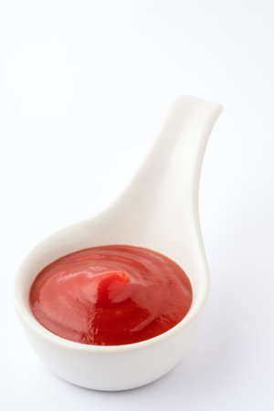 Tomato ketchup in ceramic bowl on white background.の写真素材