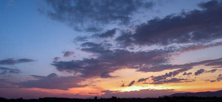 Colorful sunset and sunrise with clouds.Blue and orange color of nature.Many white clouds in the blue sky.The weather is clear today.sunset in the clouds.The sky is twilightの写真素材