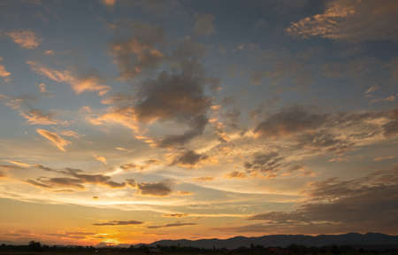 Colorful sunset and sunrise with clouds.Orange color of nature.Many white clouds in the sky.The weather is clear today.sunset in the clouds.The sky is twilightの写真素材