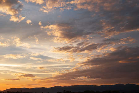 Colorful sunset and sunrise with clouds.Orange color of nature.Many white clouds in the sky.The weather is clear today.sunset in the clouds.The sky is twilightの写真素材