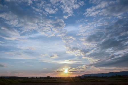 Colorful sunset and sunrise with clouds.Blue and orange color of nature.Many white clouds in the blue sky.The weather is clear today.sunset in the clouds.The sky is twilightの写真素材