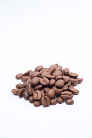 Bean coffee in white background. Medium roasted coffee beans are light brown in color in white backgroundの写真素材