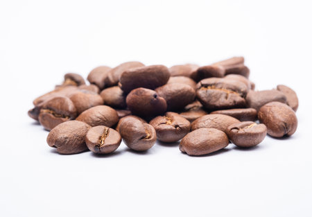 Bean coffee in white background. Medium roasted coffee beans are light brown in color in white backgroundの写真素材