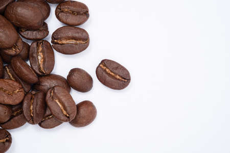 Bean coffee in white background. Medium roasted coffee beans are light brown in color in white background with copy spaceの写真素材
