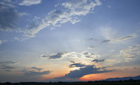 Colorful sunset and sunrise with clouds.Blue and orange color of nature.Many white clouds in the blue sky.The weather is clear today.sunset in the clouds.The sky is twilightの写真素材