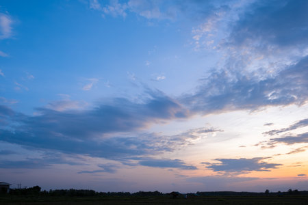 Colorful sunset and sunrise with clouds.Blue and orange color of nature.Many white clouds in the blue sky.The weather is clear today.sunset in the clouds.The sky is twilightの写真素材