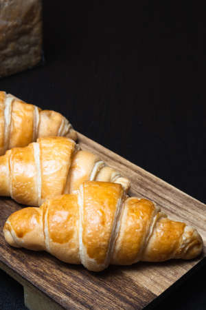 Fresh croissants on a wooden board. selective focus .bakery with copy spaceの写真素材