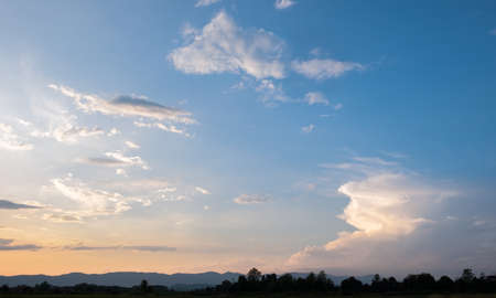 Colorful sunset and sunrise with clouds.Blue and orange color of nature.Many white clouds in the blue sky.The weather is clear today.sunset in the clouds.The sky is twilightの写真素材
