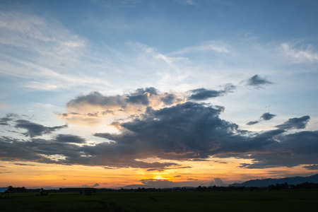 Colorful sunset and sunrise with clouds.Blue and orange color of nature.Many white clouds in the blue sky.The weather is clear today.sunset in the clouds.The sky is twilighの写真素材
