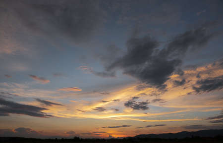 Colorful sunset and sunrise with clouds.Blue and orange color of nature.Many white clouds in the blue sky.The weather is clear today.sunset in the clouds.The sky is twilightの写真素材