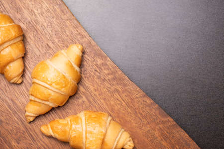 Fresh croissants on a wooden board. Freshly baked with copy space.top view croissantの写真素材