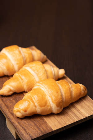 Fresh croissants on a wooden board. selective focus .bakery with copy spaceの写真素材