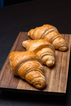 Fresh croissants on a wooden board. Freshly baked in morningの写真素材