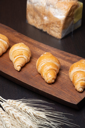 Fresh croissants on a wooden board. Freshly baked in morningの写真素材