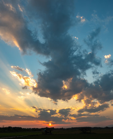 Colorful sunset and sunrise with clouds. Blue and orange color of nature. Many white clouds in the blue sky. The weather is clear today. sunset in the clouds. The sky is twilight.の写真素材