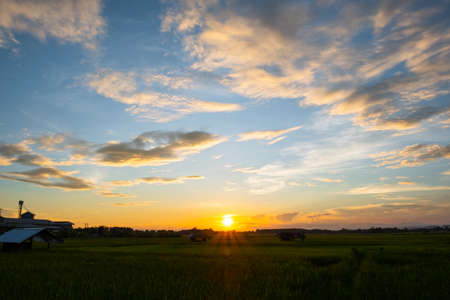 Colorful sunset and sunrise with clouds. Blue and orange color of nature. Many white clouds in the blue sky. The weather is clear today. sunset in the clouds. The sky is twilightの写真素材