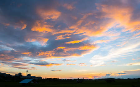 Colorful sunset and sunrise with clouds. Blue and orange color of nature. Many white clouds in the blue sky. The weather is clear today. sunset in the clouds. The sky is twilightの写真素材