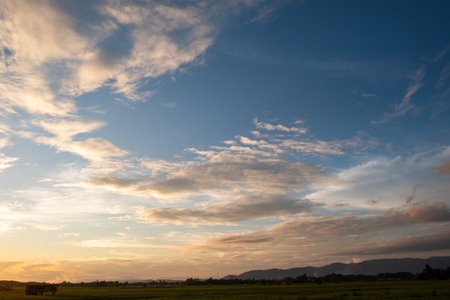 Colorful sunset and sunrise with clouds. Blue and orange color of nature. Many white clouds in the blue sky. The weather is clear today. sunset in the clouds. The sky is twilightの写真素材