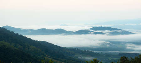 Surreal landscape of morning foggy. Morning clouds at sunrise. Landscape of fog and mountains of northern Thailand.の写真素材