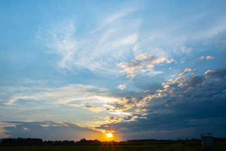 Colorful sunset and sunrise with clouds. Blue and orange color of nature. Many white clouds in the blue sky. The weather is clear today. sunset in the clouds. The sky is twilightの写真素材