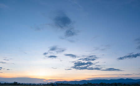 Colorful sunset and sunrise with clouds. Blue and orange color of nature. Many white clouds in the blue sky. The weather is clear today. sunset in the clouds. The sky is twilightの写真素材