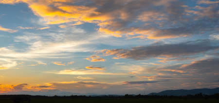 Colorful sunset and sunrise with clouds. Blue and orange color of nature. Many white clouds in the blue sky. The weather is clear today. sunset in the clouds. The sky is twilightの写真素材