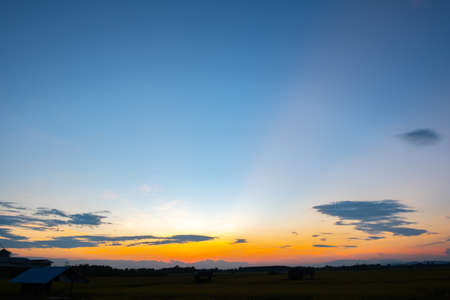 Colorful sunset and sunrise with clouds. Blue and orange color of nature. Many white clouds in the blue sky. The weather is clear today. sunset in the clouds. The sky is twilightの写真素材