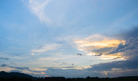 Colorful sunset and sunrise with clouds. Blue and orange color of nature. Many white clouds in the blue sky. The weather is clear today. sunset in the clouds. The sky is twilightの写真素材