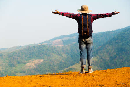Freedom traveler man standing.A man carrying a bag.People and copy space.man standing with his arms outstretched carrying a bag behind him.の写真素材