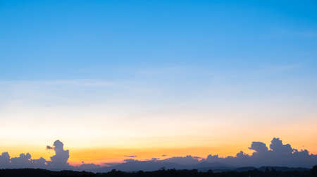 Colorful sunset and sunrise with clouds. Blue and orange color of nature. Many white clouds in the blue sky. The weather is clear today. sunset in the clouds. The sky is twilight.の写真素材