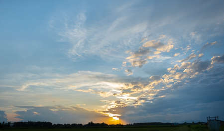 Colorful sunset and sunrise with clouds. Blue and orange color of nature. Many white clouds in the blue sky. The weather is clear today. sunset in the clouds. The sky is twilightの写真素材