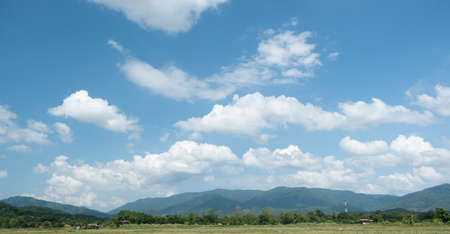 The white clouds have a quaint and rural shape. The sky is cloudy and blue.の写真素材