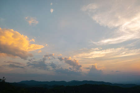 Colorful sunset and sunrise with clouds. Blue and orange color of nature. Many white clouds in the blue sky. The weather is clear today. sunset in the clouds. The sky is twilightの写真素材