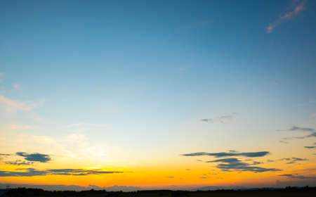 Colorful sunset and sunrise with clouds. Blue and orange color of nature. Many white clouds in the blue sky. The weather is clear today. sunset in the clouds. The sky is twilightの写真素材