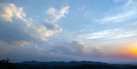 Colorful sunset and sunrise with clouds. Blue and orange color of nature. Many white clouds in the blue sky. The weather is clear today. sunset in the clouds. The sky is twilightの写真素材