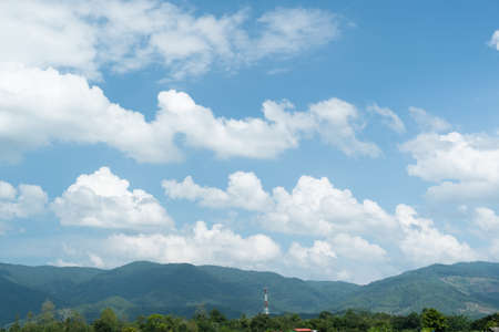 The white clouds have a quaint and rural shape. The sky is cloudy and blue.の写真素材